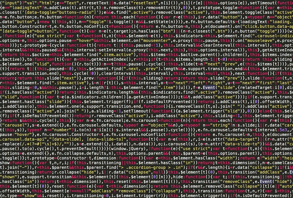 A close-up photograph of a computer screen displaying lines of code in various colours, including red, green, blue, and purple, on a dark background. The screen shows a debugging or development enviro